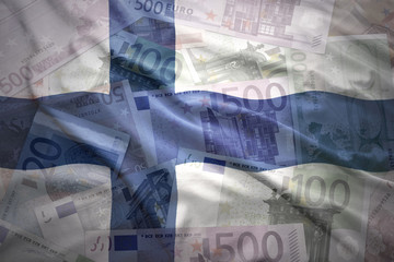 colorful waving finnish flag on a euro money background