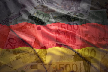 colorful waving german flag on a euro money background © luzitanija