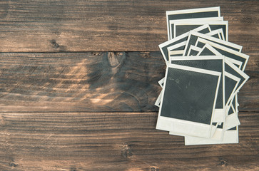 Old instant polaroid photo frames on rustic wooden background