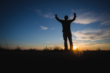Fototapeta na wymiar silhouetted man standing in sunset sky