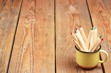 Fototapeta na wymiar Pencils in a mug on a wooden table
