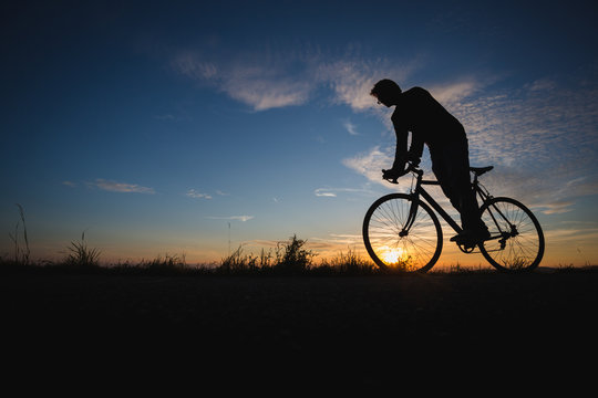 silhouetted cyclist in sunset