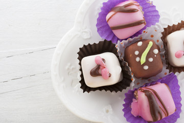 Mignon small sweet cakes on a wooden white board