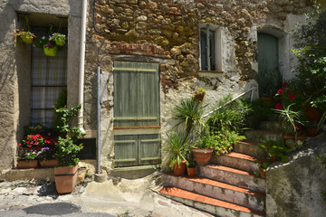Fototapeta na wymiar Vieille façade à l'escalier fleuri à Bagnols en forêt (83600), département du Var en région Provence-Alpes-Côte-d'Azur, France