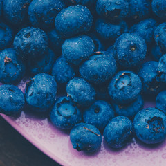 Old bowl of fresh organic blueberries on wooden table.Soft focus