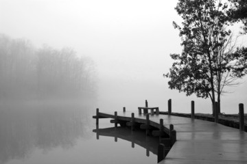 Fototapety  Gruby koc z mgły zakrywa jezioro i drewniany dok