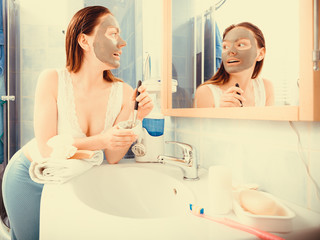 Obraz na płótnie Canvas Woman applying mud facial mask