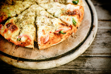 Vintage retro effect filtered hipster style image of pizza on wo
