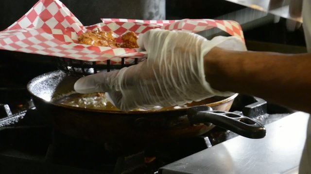 Chef putting onion rings in a basket
