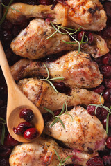 Baked chicken leg with cherry macro. Vertical top view
