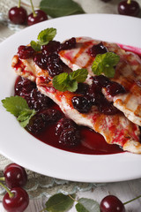 Grilled chicken with cherry sauce on a plate close-up. Vertical
