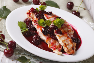 Grilled chicken with cherry sauce on a plate close-up. horizontal