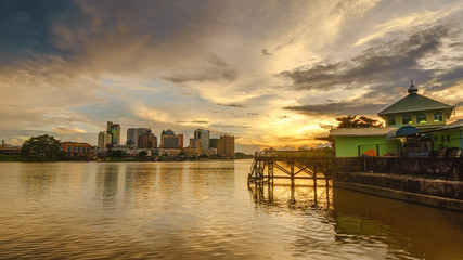 Sunset view of Sarawak river with an ancient old mosque by the riverside.