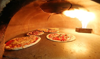pizzas in the oven with the hot flame