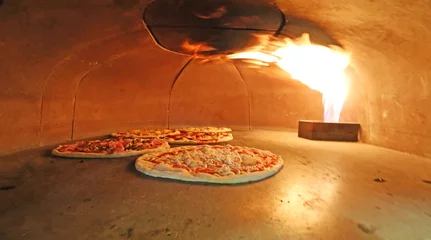 Crédence de cuisine en verre imprimé Pizzeria pizzas italiennes au four avec la flamme chaude