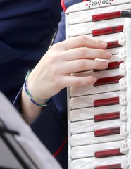hand of a young woman plays the ancient accordion