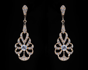 gold earrings with jewels on the black