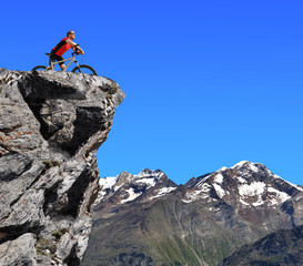 Cyclist on bike. In the background Pennine Alps, Switzerland.