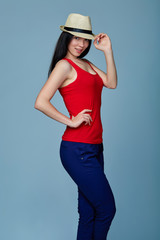 Naklejka premium Natural smiling teen girl posing in blank red tshirt and straw h