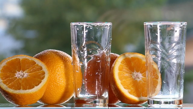 Oranges and orange juice on a green background.