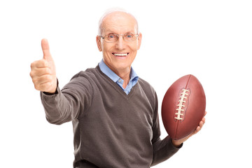 Senior holding a football and giving thumb up