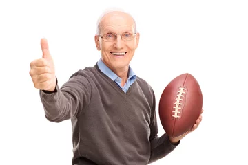 Fotobehang Senior holding a football and giving thumb up © Ljupco Smokovski