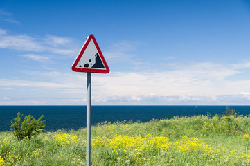 Precipice edge warning sign. Danger sea cliff hidden by grass an
