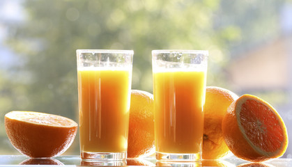 Oranges and orange juice on a green background.