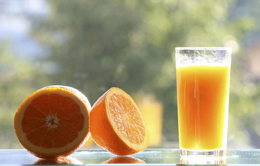 Oranges and orange juice on a green background.