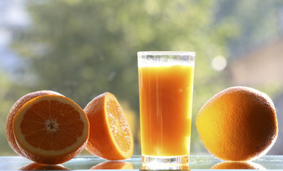 Oranges and orange juice on a green background.