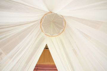 white mosquito net over a bed in a luxurious hotel