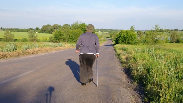Senior man walking away on a country road with expressive gesticulation
