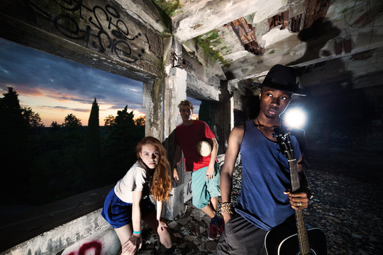 friends having fun playing music in an urban place