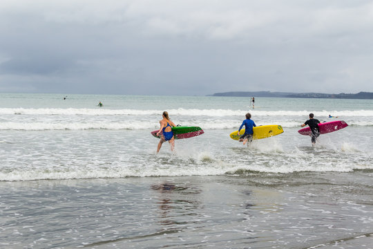 Young lifeguards with boards on beach