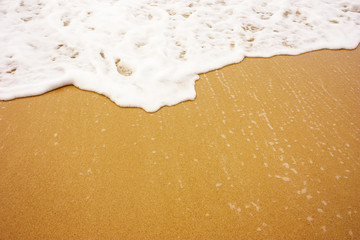Sea wave with foam on sand
