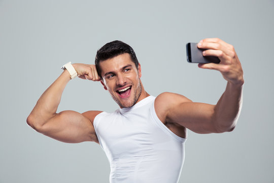 Cheerful sports man making selfie photo on smartphone