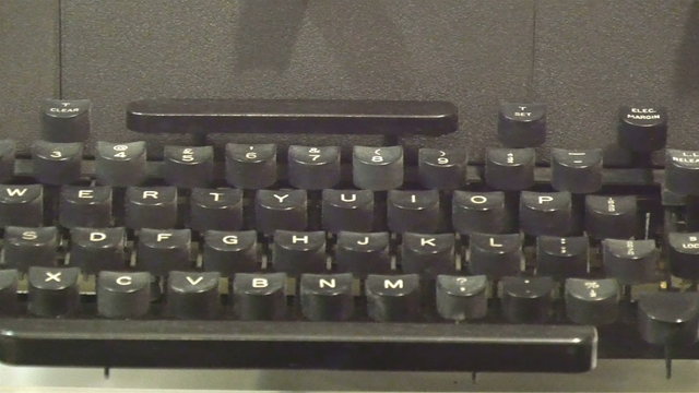 An old black model of a typewriter. With the big black keys with letters