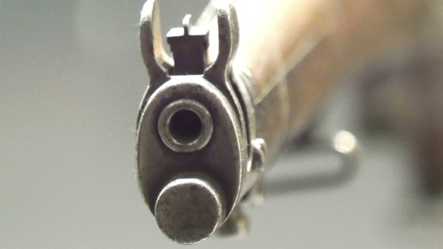 The front of a shot gun in display. With its hole infront where the bullet gets out