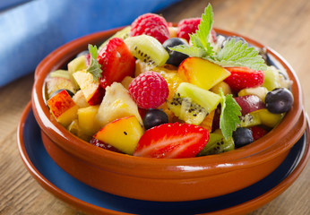 Healthy homemade fruit salad on a  wooden background.