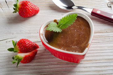 Homemade Chocolate Mousse  in a heart-shaped bowl on a wooden ba