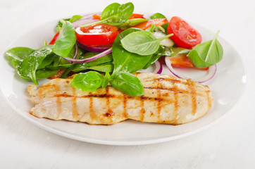 Fresh Salad with grilled chicken on a white plate.