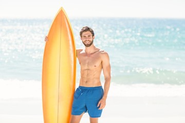 Handsome man holding surfboard 