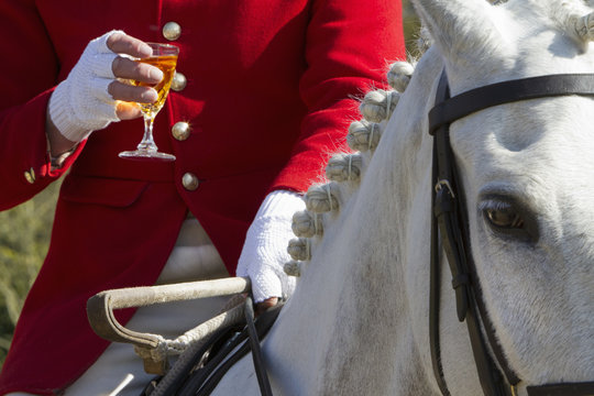A Master of Foxhounds having a drink at a hunt meet. 