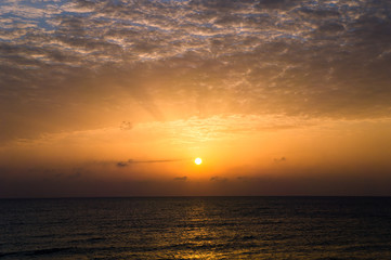 Fototapeta premium Dramatic sunset with dark clouds in the sea