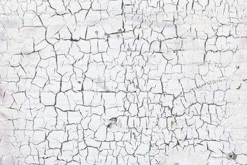abstract pattern of cracks in white washed wall