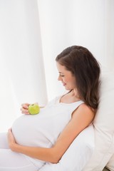 Obraz na płótnie Canvas Happy pregnancy with an apple on his belly 
