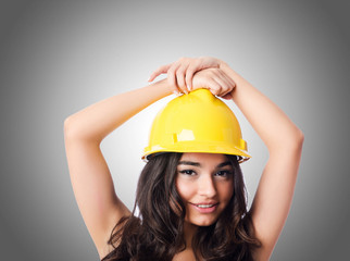 Young woman with hellow hard hat against gradient 