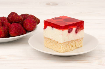 A piece of strawberry cheesecake on the wooden background.