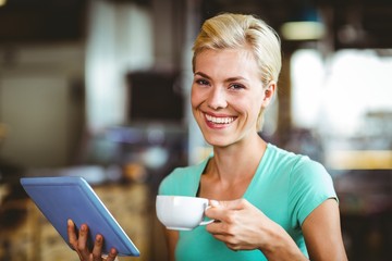  Pretty blonde having a coffee using tablet pc