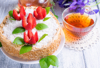 Celebratory cake with strawberries flowers, tea and irises